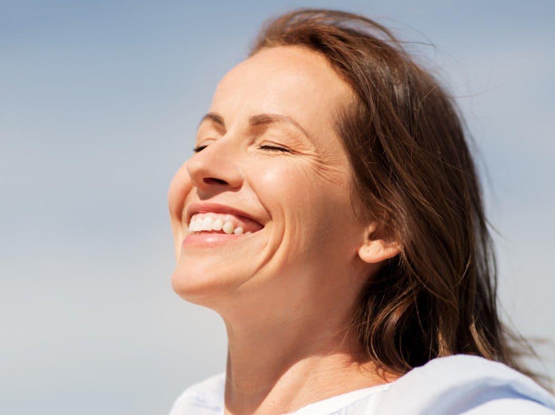 Close-up of a woman's face with a digital laser beam aimed at her eye, next to the text: Laser Eye Surgery for Astigmatism – What You Should Know Beforehand, including how LASIK can help correct vision.